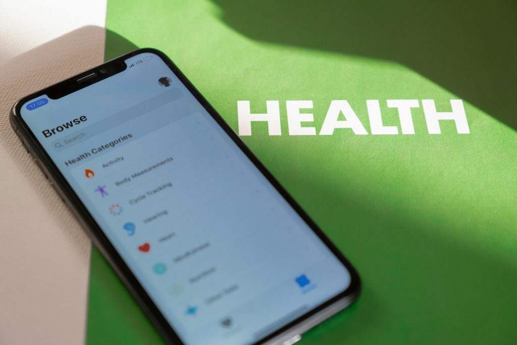 pexels photo 4108167 4108167 Close-up of a smartphone displaying a health app on a green surface with 'HEALTH' text.