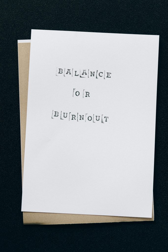 A simple card displaying the message 'Balance or Burnout' emphasizing mental health and stress management.