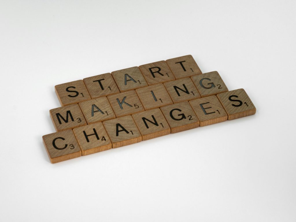 Scrabble tiles on a white surface spelling 'Start Making Changes'.